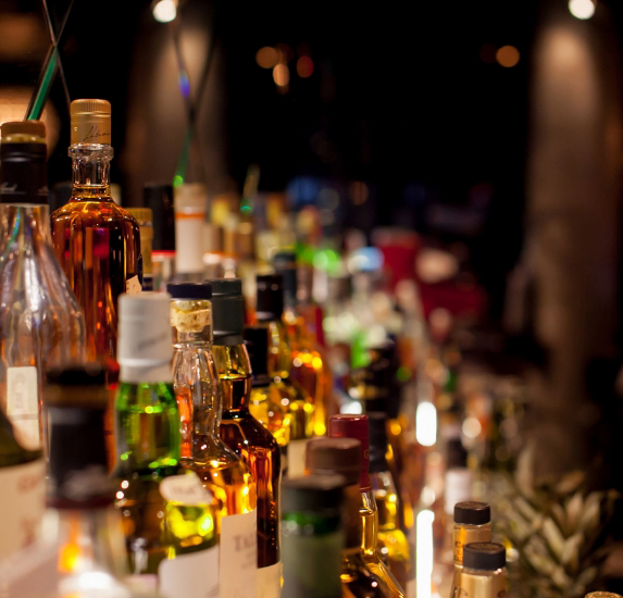 Shelf at a bar filled with various alcoholic beverages