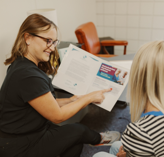 Laura showing a pamphlet to a patient