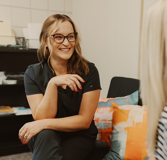 Laura smiling while talking to an addiction patient in Kansas City