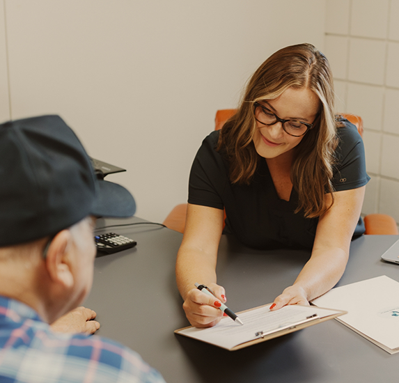 Laura showing a clipboard to a patient for addiction treatment in Kansas City