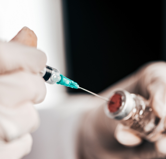 Medical professional drawing a syringe from a vial